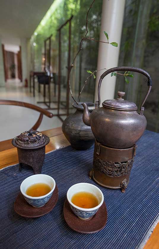 Antique metal teapots and delicate porcelain cups.