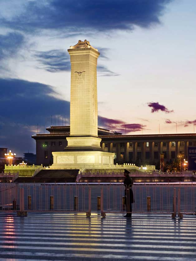 Monument to the People's Heroes and Armed Police with the Great Hall of the People in the background.